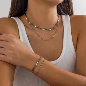 Close-up of minimalist silver double layer snake bone and twisted wave chain jewelry set