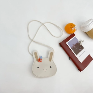 Detail view of cream white PU leather bunny cross-body bag with orange flower decor