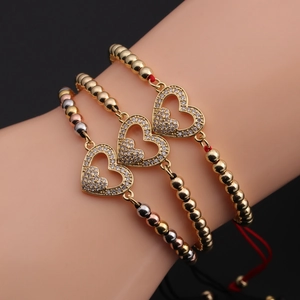 Détail de trois bracelets cœur ajustables avec perles dorées et pavé en oxyde de zirconium