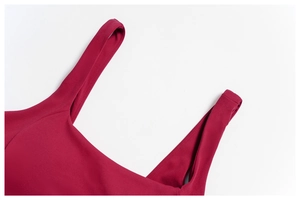 Close-up of red sports bra shoulder straps with fine stitching and breathable fabric