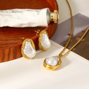 Detailed view of French vintage baroque pearl necklace and earrings set in gold finish