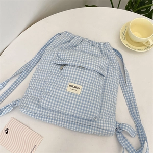 Detail of blue and white gingham quilted backpack with heart stitching and front pocket