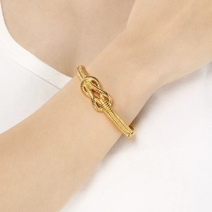 Fashionable gold knot cuff bracelet for women featuring intricate woven metal texture
