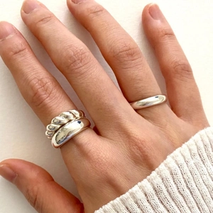Close-up of minimalist S925 sterling silver rings set with glossy and twisted band designs