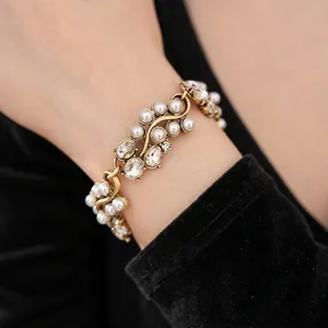 Vintage gold-tone link bracelet with oval pearls and sparkling crystals on model's wrist