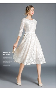 Detail of elegant white floral lace embroidery and 3/4 sleeves on midi dress