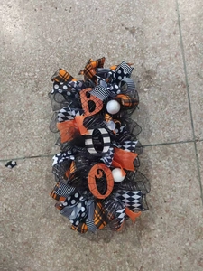 Detail of BOO Halloween wreath with orange mesh ribbons and spider web patterns