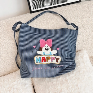 Detail of blue striped canvas bag featuring cute puppy embroidery and colorful Happy text