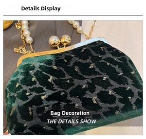 Close-up of dark green velvet shell bag with pearl clasp and vintage gold metal frame