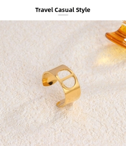 Detail view of adjustable 18K gold plated steel ring with CD logo on stone background