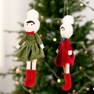 Nordic plush Christmas girl doll pendants in red and green dresses hanging on a festive tree