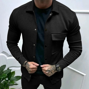 Detail of black twill jacket featuring chest pocket and premium metal button fastening