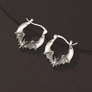 Macro detail of gothic bat earrings in vintage silver finish with textured wings