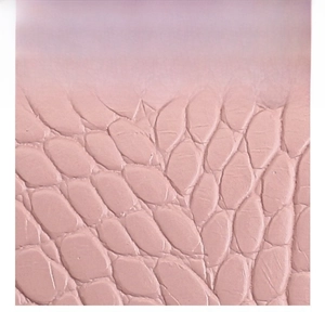 Close-up of pink faux leather featuring high-quality crocodile and pebble grain texture
