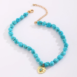 Close-up of Bohemian turquoise beaded necklace with golden heart pendant and lobster clasp