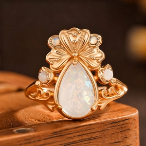 Vue détaillée d'une bague trèfle vintage dorée avec opale poire et gravures fines