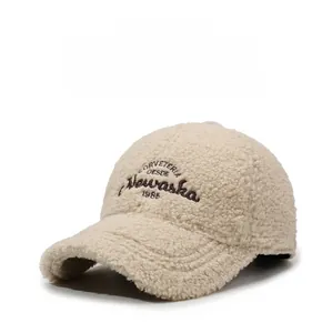 Détail de la texture de casquette beige en laine d'agneau avec broderie vintage marron