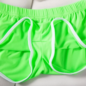 Detailaufnahme der neongrünen Sport-Shorts mit weißem Rand und elastischem Taillenbund