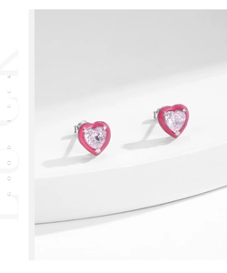 Macro detail of S925 sterling silver heart earrings with pink zircon and enamel finish