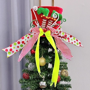 Close-up of festive Christmas tree topper hat with elf legs and colorful candy cane accents