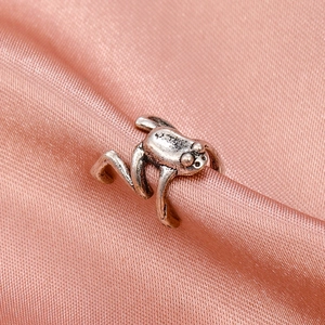 Vintage silver frog ear cuff with retro textured finish on elegant satin fabric