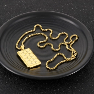 Gros plan d'une chaîne dorée avec pendentif rectangulaire en nid d'abeille et diamants incrustés