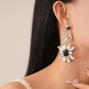 Close-up of luxury geometric flower earrings with sparkling crystals and black gemstones
