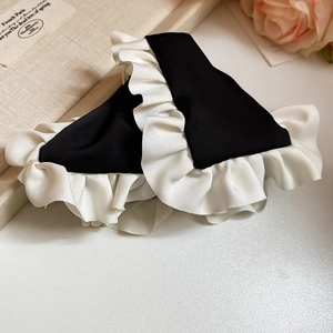 Close-up of black and white silk fabric hair claw clip with elegant ruffled layers