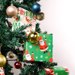 Christmas gift wrapping paper featuring Santa patterns and festive ornaments on a tree