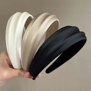 Detailed view of seersucker bow headbands in white, champagne, and black satin texture