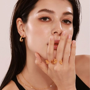 Elegant 18k gold butterfly ring and hoop earrings jewelry set on a female model
