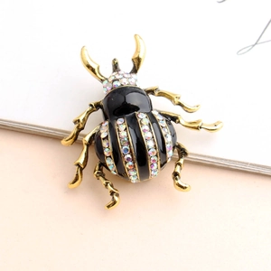 Close-up of beetle brooch with gold-tone alloy frame and vibrant colorful rhinestones