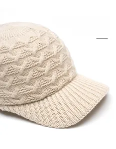 Detailed cable knit pattern on beige baseball cap with flexible wide brim and ribbed edge