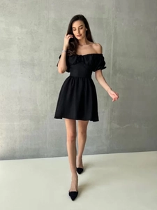 Detail eines schwarzen Off-Shoulder-Minikleids mit Puffärmeln und tailliertem Schnitt