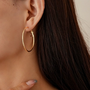 Polished gold geometric round hoop earrings shown on a model for a stylish look
