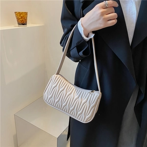 French style cream quilted shoulder bag for women worn by a model in a black blazer