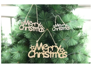 Three wooden Merry Christmas hanging signs in various sizes on a festive green pine tree