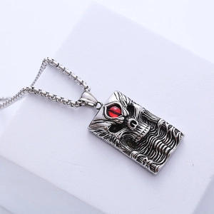 Pendentif gothique tête de mort avec pierre rouge sur plaque rectangulaire argentée