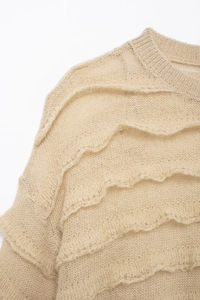 Detail of beige mohair sweater featuring artistic ruffled layers and soft knit texture