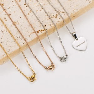 Detailed shot of gold and silver heart necklaces with Forever Loved engraving