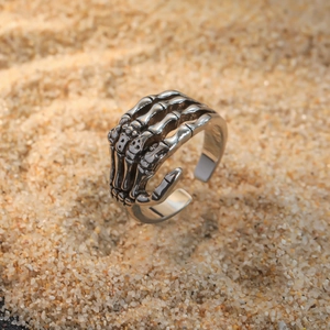Vintage punk skeleton hand open adjustable ring in retro silver metal finish on sand