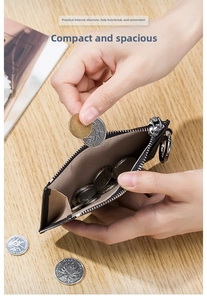Close-up of black litchi grain leather coin purse with silver zipper and keychain