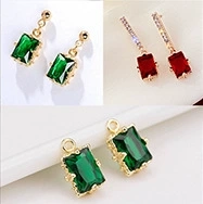 Detailed view of 14K gold plated earrings with rectangular green and red gemstones