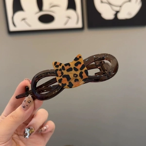 Detail of leopard print cat head ornament on brown acrylic large shark hair claw clip