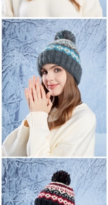 Close-up of winter knit hat featuring blue geometric patterns and a large fluffy pom-pom