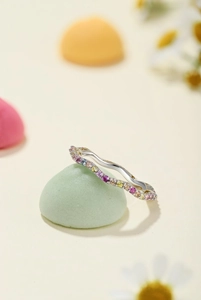 Macro shot of silver wave ring with colorful cubic zirconia and polished finish