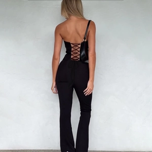 Chic black strapless jumpsuit featuring a lace-up corset back and slim fit flare legs