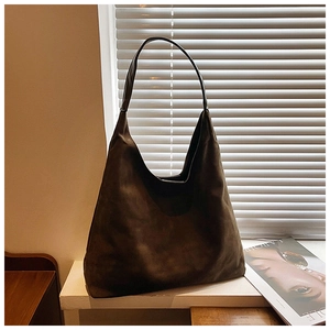 Detail of a large brown suede tote bag featuring a minimalist Hobo style matte texture
