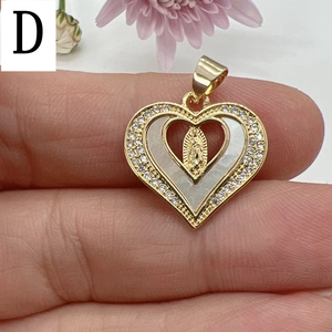 Macro detail of gold heart pendant with white mother of pearl and Guadalupe relief