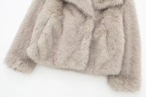 Close-up of soft faux fox fur texture on a light grey winter coat collar detail
